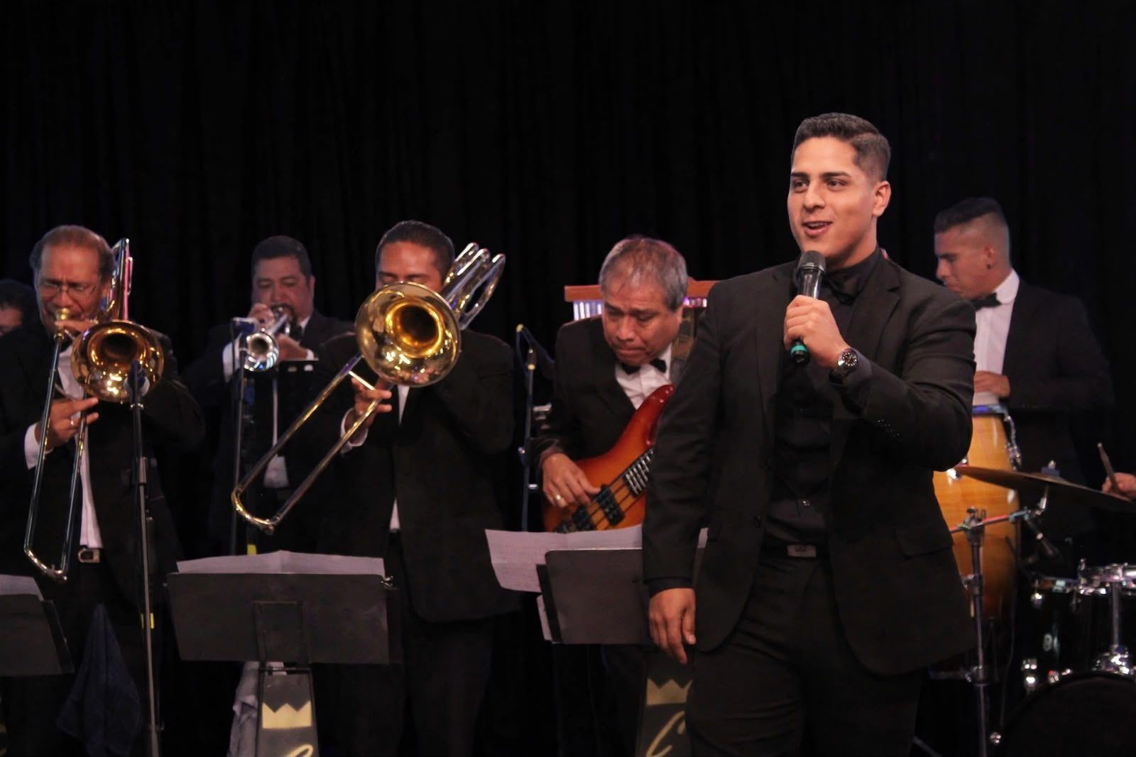 La orquesta en escena con los metales y la voz durante una presentación